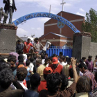 Los cristianos paquistanís y los equipos de rescate se reúnen fuera de una iglesia dañada por un ataque suicida.