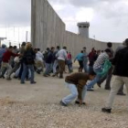 Varios manifestantes palestinos cruzan una zona del Muro de Cisjordania en obras