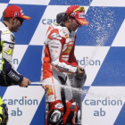 Valentino Rossi y Toni Elias rocían a una azafata con champán en el podio de Brno, en el 2009.