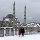 Varios transeúntes caminan por un nevado puente de Galata, en Estambul, este miércoles.