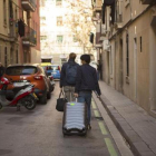 Dos turistas con su equipaje en una calle de la Barceloneta.