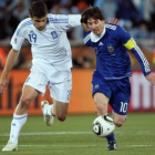 El argentino Messi y el griego Sokrat pugnan por un balón.