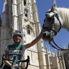Miguel Ángel Benito posa con la elástica de su equipo, el Caja Rural, delante de la Catedral de León, mientras acaricia a un caballo