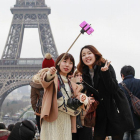 Turistas utilizando del palo para hacerse selfis en París.