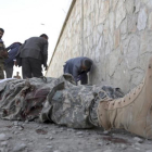 Militares inspeccionan el cadáver de un miliciano en la sede del Ministerio del Interior afgano, en Kabul.