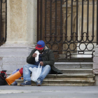 Una persona come en la calle tras recoger la comida de la Asociación de Caridad. FERNANDO OTERO