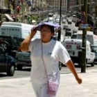 Una mujer se tapa la cabeza ante el sofocante calor de los últimos días