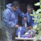 Trabajadores sanitarios con trajes protectores toman muestras de hortalizas.