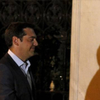 Fotografía en que se ve como el borde de una pared alarga la sombra de la nariz de Tsipras.