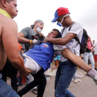 Un hombre herido es ayudado, ayer, en Ureña, donde se esperaba ayuda humanitaria. DEIBISON TORRADO