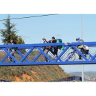 Peregrinos caminan por la pasarela del Alto del Portillo en su senda de entrada a la capital de la provincia.