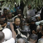 El expresidente haitiano Jean Claude Duvalier, en el centro, es custodiado por la policía.