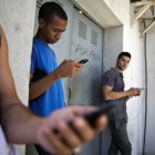 Tres jóvenes cubanos, con sus 'smart phones', en una calle de La Habana, este martes.
