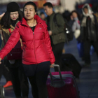 Varios viajeros en la estación de Pekín para regresar a sus lugares de origen.