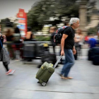 Una pareja con sus maletas y mochilas, ayer en una calle de Barcelona.