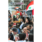 Sirios seguidores del régimen ondeando banderas.