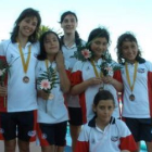 Las jóvenes nadadoras leonesas posan junto a las medallas conseguidas.