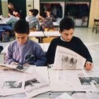 Los niños recortan noticias de un periódico para sus actividades de la escuela