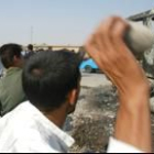Un iraquí lanza una piedra contra un convoy americano atacado al sur de Bagdad