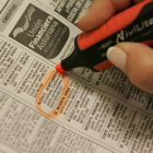 Una mujer señala un anuncio de alquiler de un apartamento en el periódico.