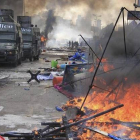 Tiendas de campaña arden junto a vehículos blindados de la policía en la acampada de los seguidores de Mursi en la plaza de Rabea al Adauiya en El Cairo.
