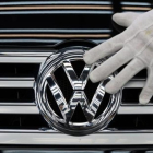Un empleado coloca el logotipo de Volkswagen a un vehículo.