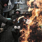 Un hombre añade combustible a una barricada en Kiev.