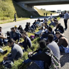 Un grupo de refugiados descansan en medio de una autopista en el sur de Dinamarca.
