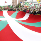 Una ikurriña preside la multidunaria manifestación exigiendo la independencia de Euskadi.