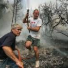 Dos voluntarios ayudan a sofocar el incendio que arrasa desde el pasado jueves la Sierra Calderona