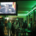 Un grupo de personas escuchan el mensaje televisado de Robert Mugabe. KIM LUDBROOK