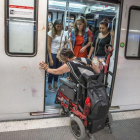 Una mujer en silla de ruedas intenta acceder al vagón del metro