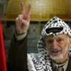 Arafat, enfermo y envejecido, hace la señal de la victoria desde su despacho en la Mukata de Ramala