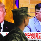 Un soldado surcoreano pasa frente a un televisor en Seúl mientras aparecen en la pantalla Donald Trump y Kim Jong un.