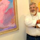 El artista Alberto Cavazos posa junto a dos de sus obras