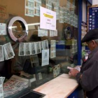 Un hombre sella su boleto de apuestas en una oficina de lotería.