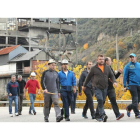 Un grupo de los trabajadores que participan en la marcha, a su paso por Santa Cruz del Sil, junto al viejo lavadero de carbón que es el símbolo de una época dorada. L. DE LA MATA