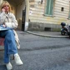 La nieta de Mussolini habla por teléfono sentada en una calle de Roma