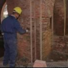 Un operario trabaja en las obras de restauración de un edificio en un pueblo de la provincia de León