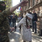 Un hombre conduce a la activista y periodista ucraniana Imra Krat, retenida por prorrusos.