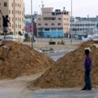 Niños palestinos juegan sobre trincheras de arena preparadas ante un posible ataque