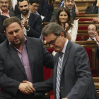 El presidente de la Generalitat, Artur Mas, estrecha la mano del lider de ERC, Oriol Junqueras, ante el aplauso de sus compañeros de partidos, tras la aprobación, hoy en el pleno del Parlamento de Cataluña, de una resolución pactada por los cuatro partido