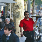 Un camarero trabajando en una terraza de un bar del Passeig de Gràcia de Barcelona. /