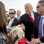 Trump (centro) saluda a varios ciudadanos a su llegada al aeropuerto internacional de Saint Louis, el 29 de noviembre.