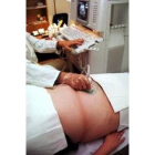 Un ginecólogo realiza una ecografía a una embarazada
