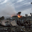 Un miliciano observa parte de los restos del avión de Malaysia Airlanes.