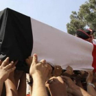 Un féretro con los restos de un policía muerto en los disturbios del miércoles es trasladado por sus compañeros, durante los funerales celebrados este jueves en El Cairo.