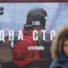 Una mujer pasa ante un cartel que representa a un soldado ruso ayer, en Moscú. MAXIM SHIPENKOV