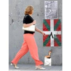 Una mujer pasa ante una ikurriña y el anagrama de ETA, ayer en Bilbao