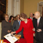 La Reina Doña Sofía observa el atlas durante la presentación